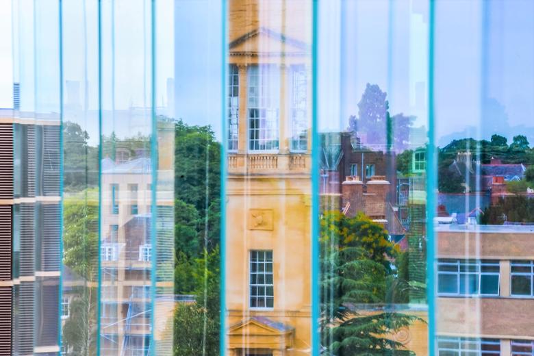 Image of the Radcliffe observatory taken from a window with a number of different reflections including buildings, tree